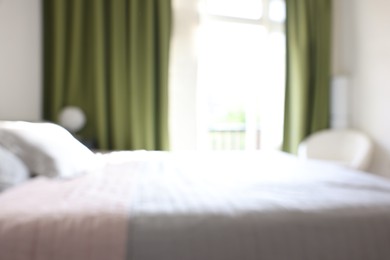 Photo of Blurred view of large bed near window in room