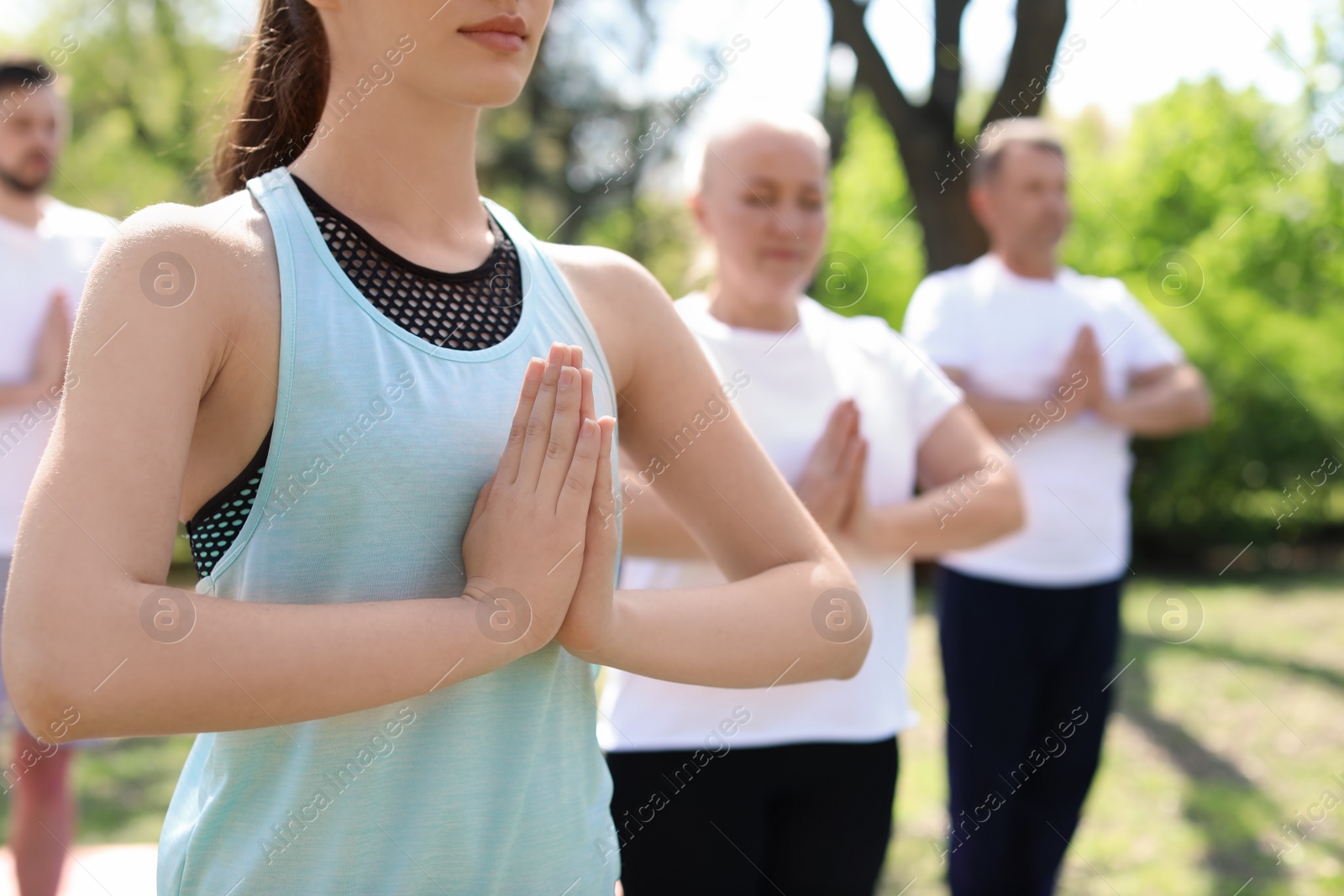 Photo of Group of people practicing yoga in park on sunny day