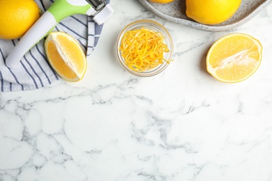 Lemon zest and fresh fruits on white marble table, flat lay. Space for text