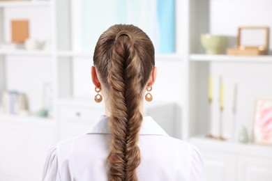 Woman with braided hair at home, back view