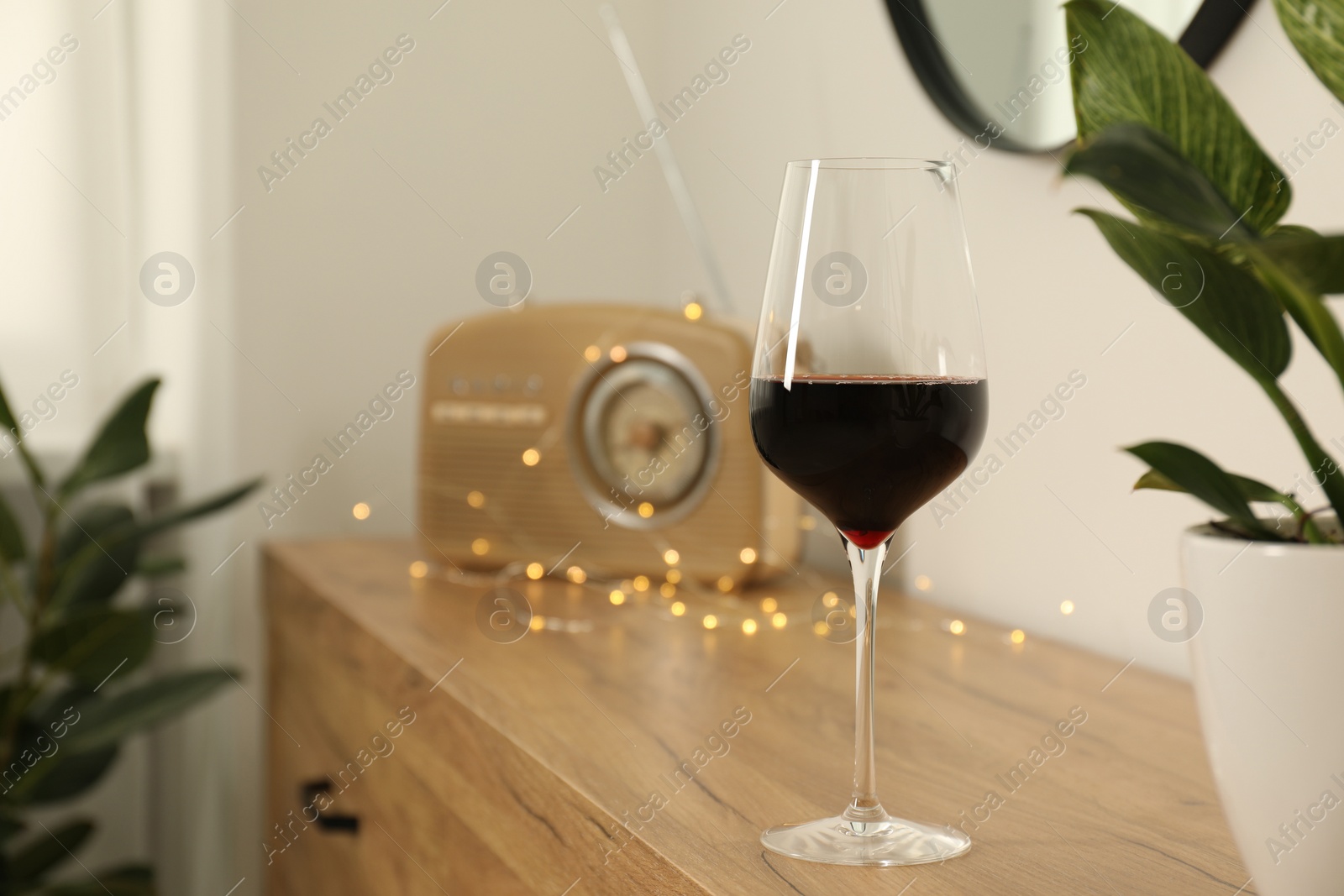 Photo of Red wine on chest of drawers in room, space for text. Relax at home