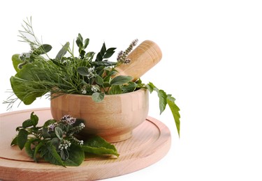Photo of Wooden board and mortar with different herbs, flowers and pestle on white background