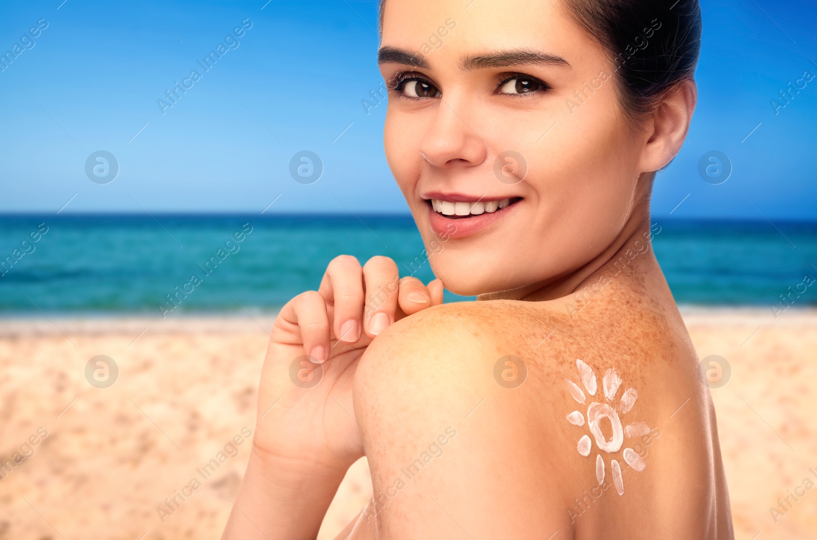 Image of Sun protection. Beautiful young woman with sunblock on her back near sea, closeup