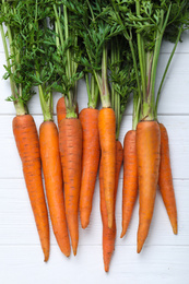 Ripe carrots on white wooden background, flat lay