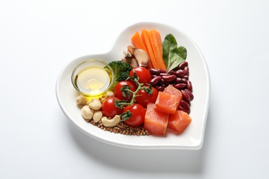 Photo of Plate with products for heart-healthy diet on white background