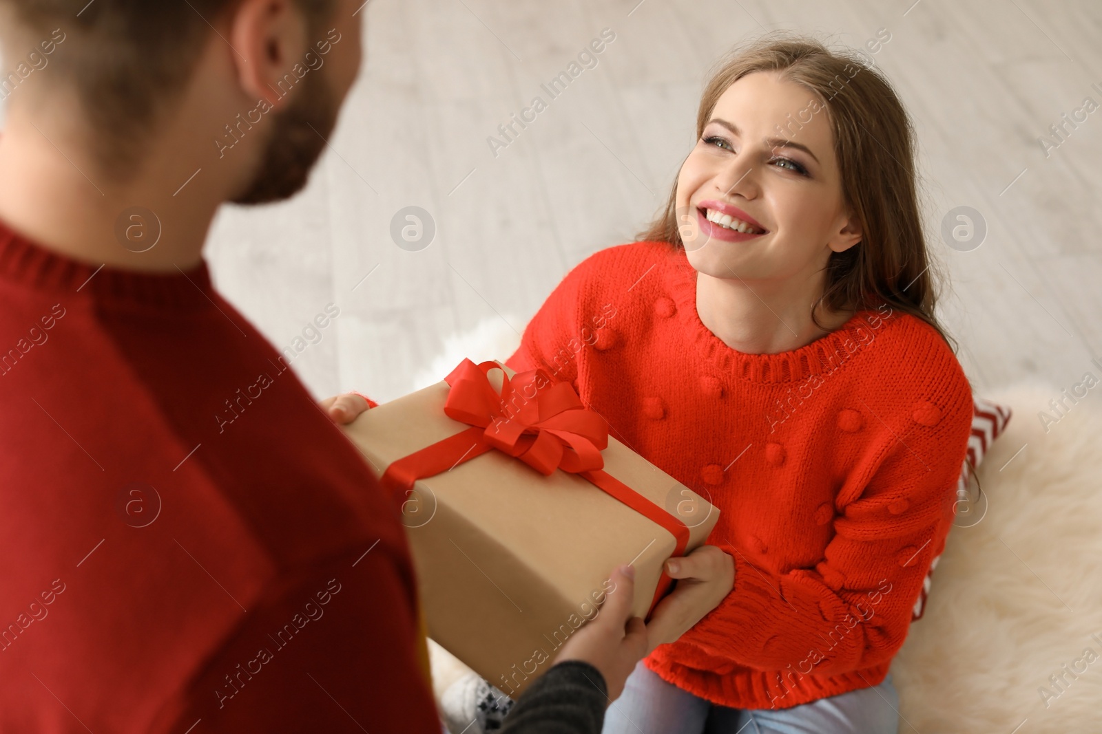 Photo of Happy young couple with Christmas gift box at home
