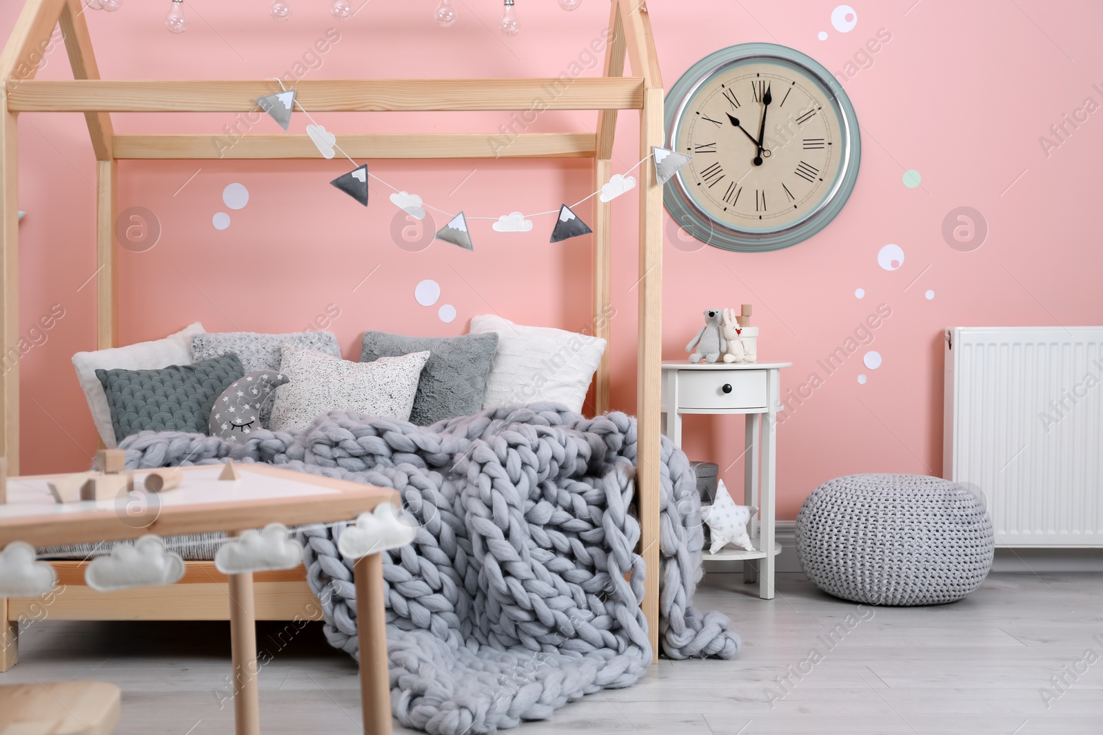 Photo of Child's room interior with comfortable bed and garland