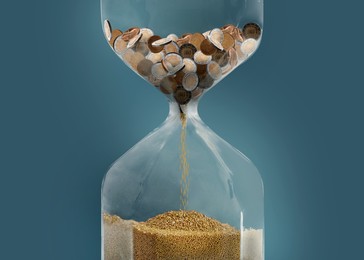 Image of Time is money. Hourglass full of coins converting into golden sand on blue background