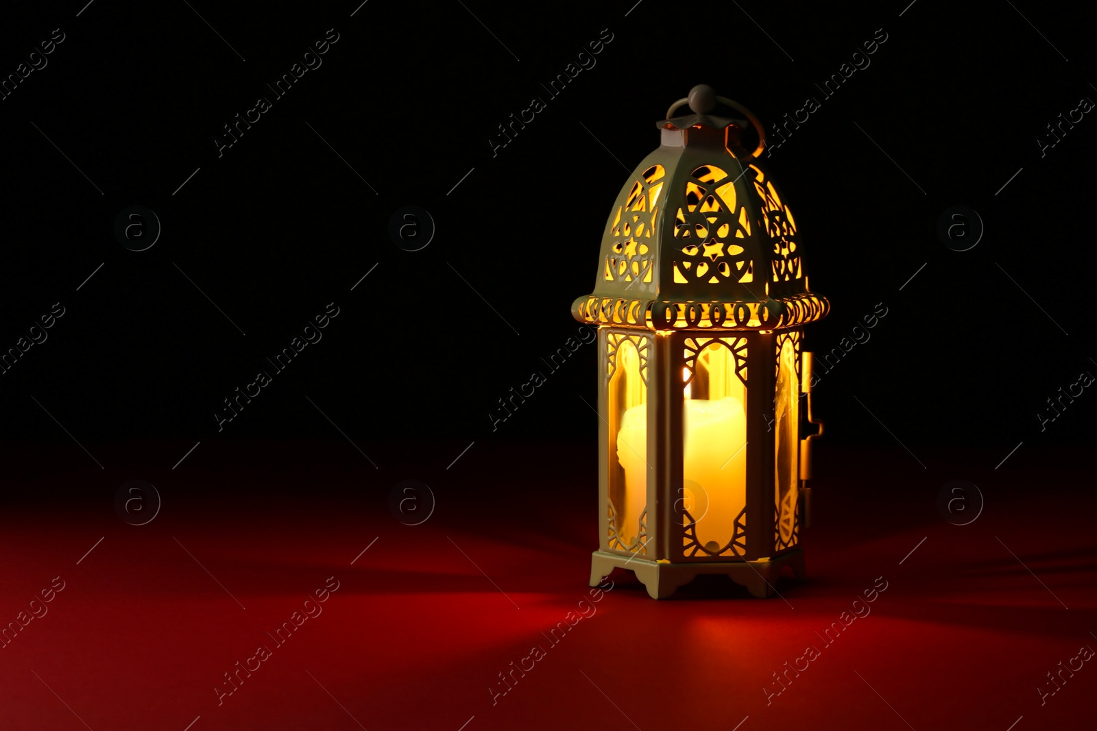 Photo of Decorative Arabic lantern on table against dark background. Space for text