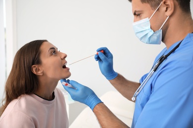 Doctor taking sample for DNA test from woman in clinic