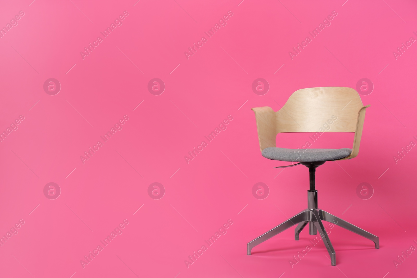 Photo of Comfortable office chair on pink background, space for text