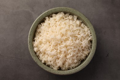 Photo of Delicious rice in bowl on grey table, top view