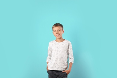 Photo of Adorable little boy in casual clothes on color background