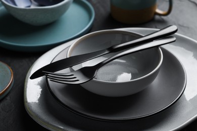 Photo of Setclean tableware on black table, closeup
