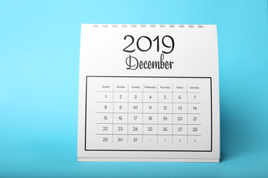 Photo of Paper calendar on light blue background. Planning concept