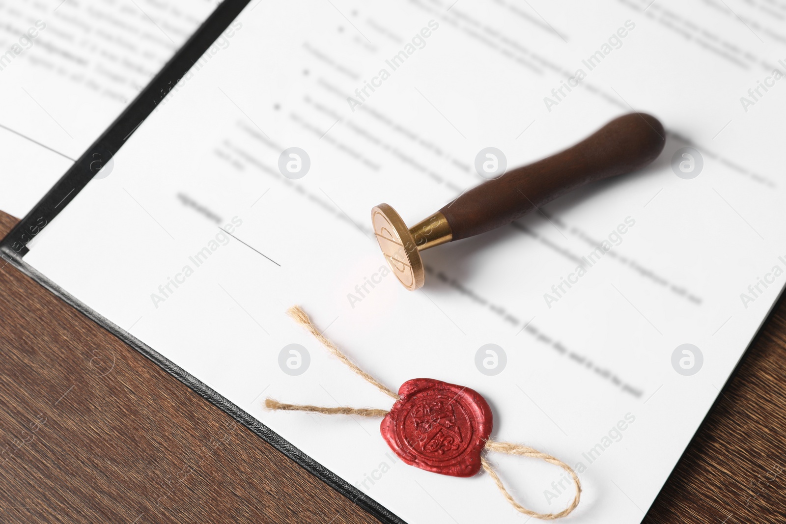 Photo of Documents and stamp on wooden table, above view. Notary contract