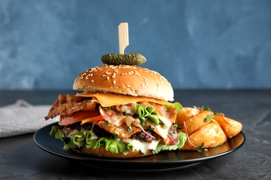 Tasty burger with bacon served on table