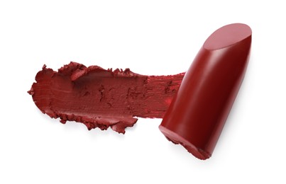 Photo of Bright lipstick and smear on white background, top view