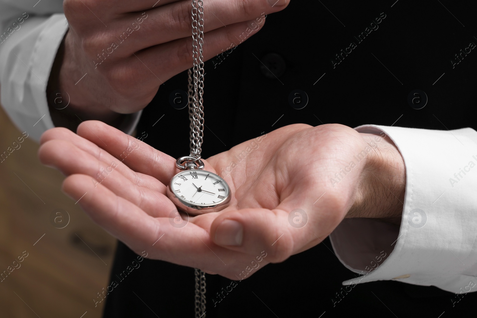 Photo of Man holding chain with elegant pocket watch, closeup