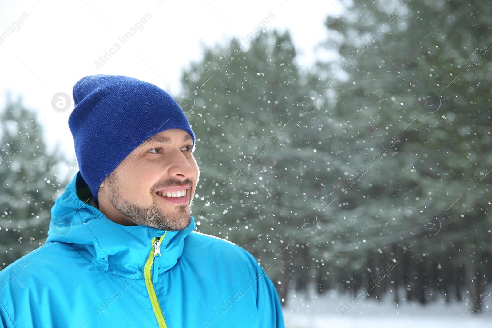 Photo of Portrait of happy man in snowy forest. Space for text