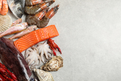 Fresh fish and seafood on marble table, flat lay. Space for text