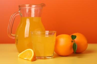 Fresh oranges and juice on yellow table, closeup