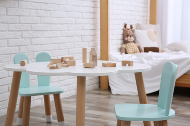 Little table and chairs with bunny ears in baby room. Interior design