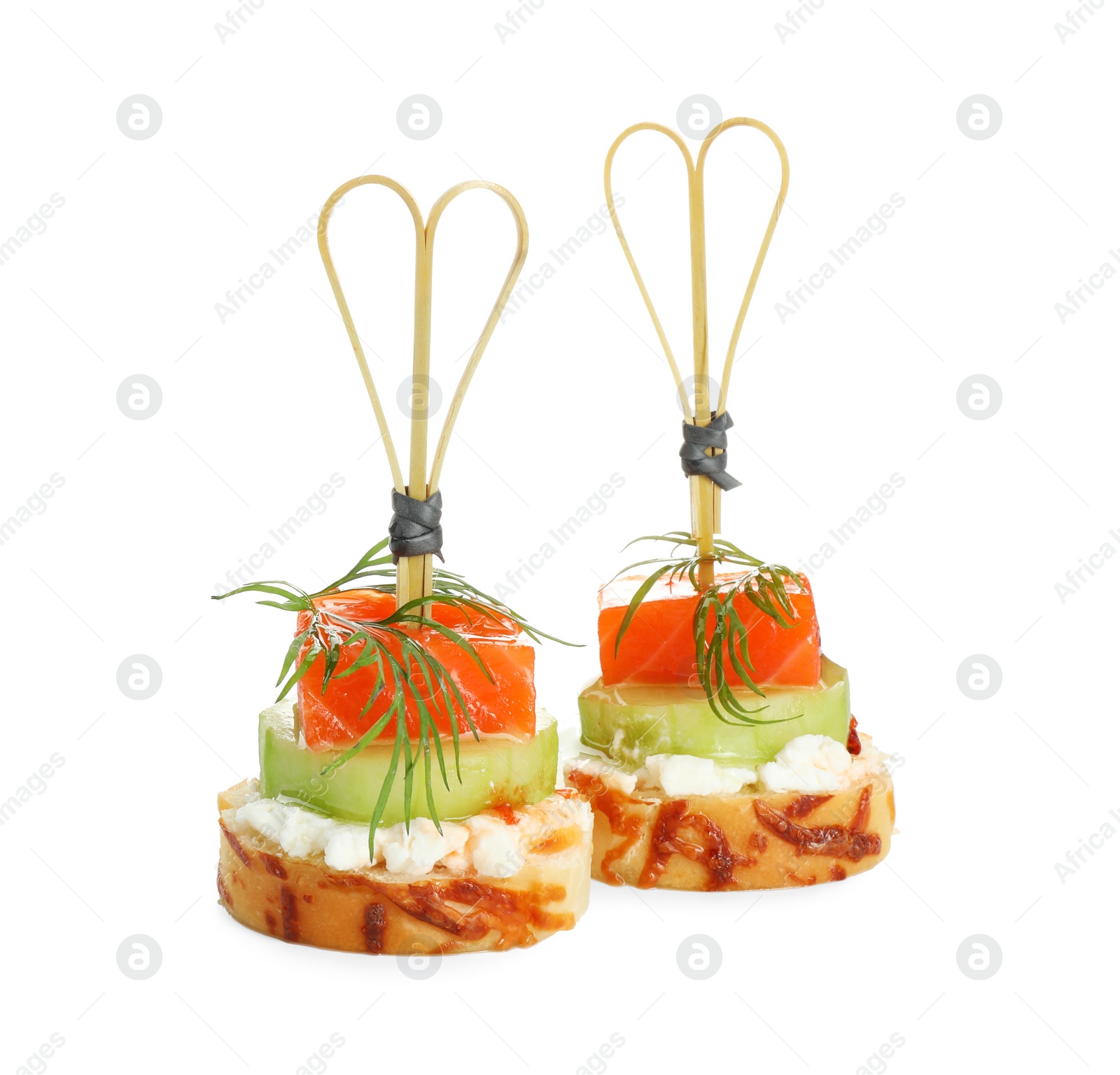 Photo of Tasty canapes with salmon, cucumber, bread and cream cheese isolated on white