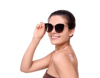 Beautiful young woman in sunglasses with sun protection cream on her back against white background