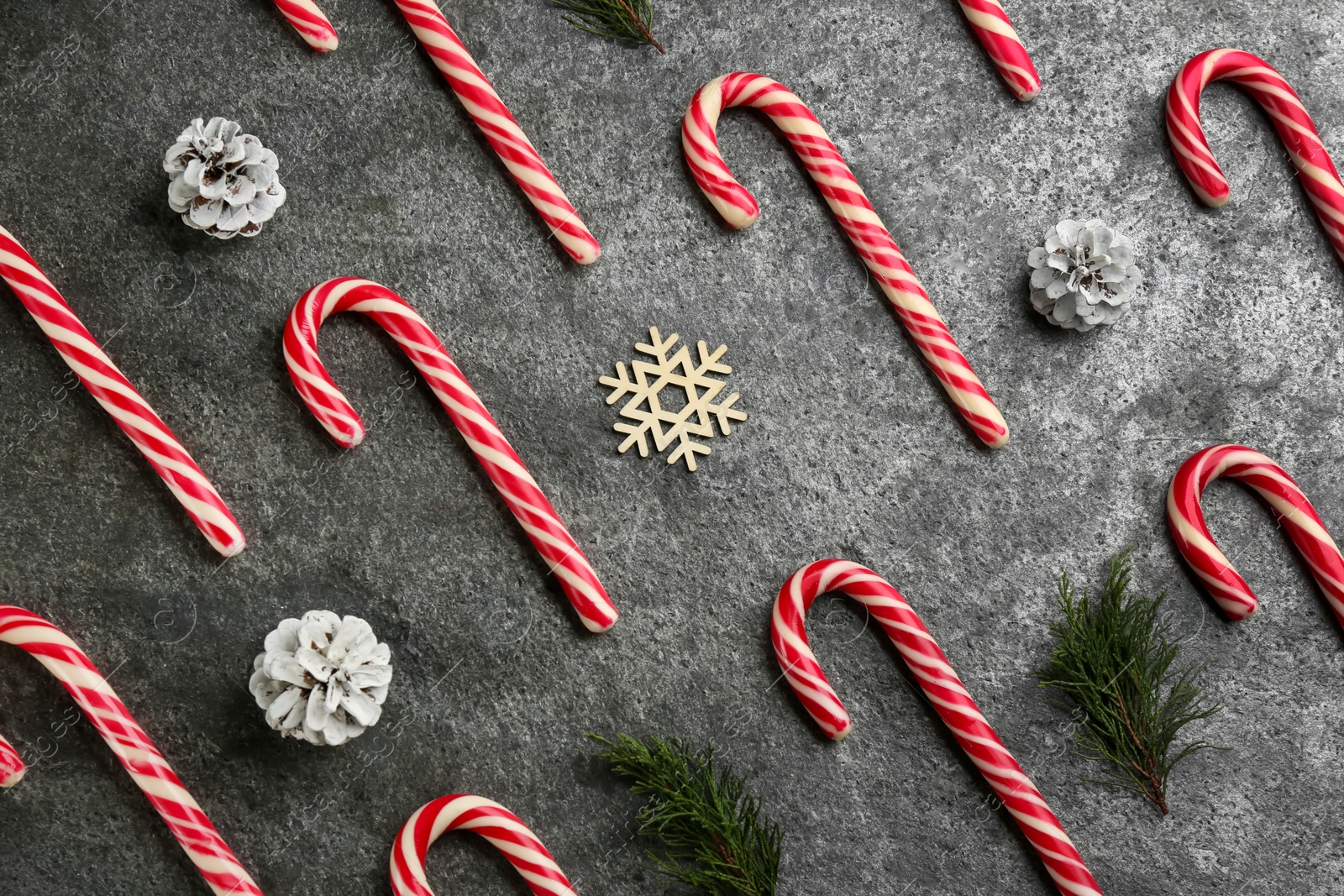 Photo of Flat lay composition with candy canes and Christmas decor on grey table