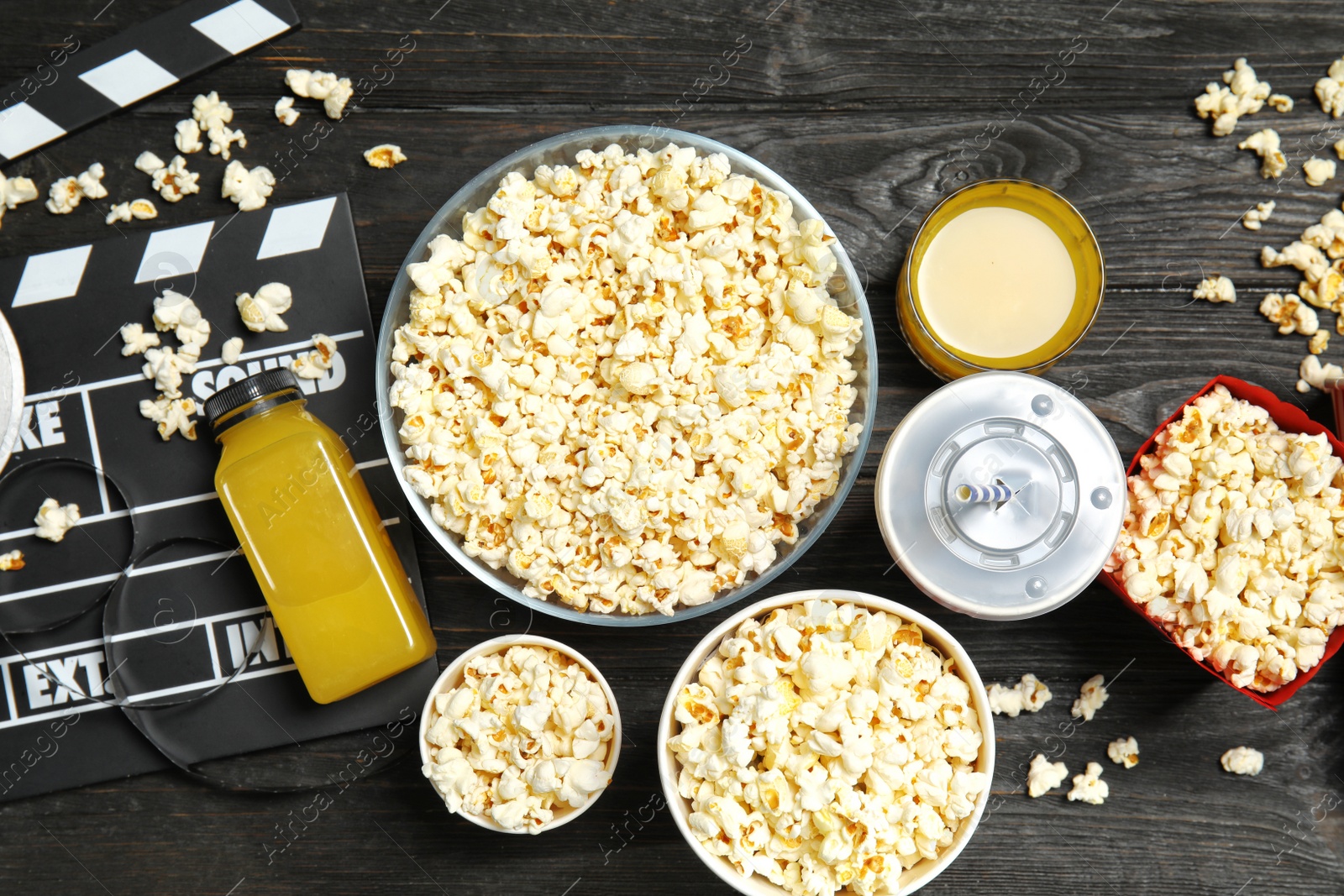 Photo of Flat lay composition with popcorn, cinema clapperboard and drinks on wooden background