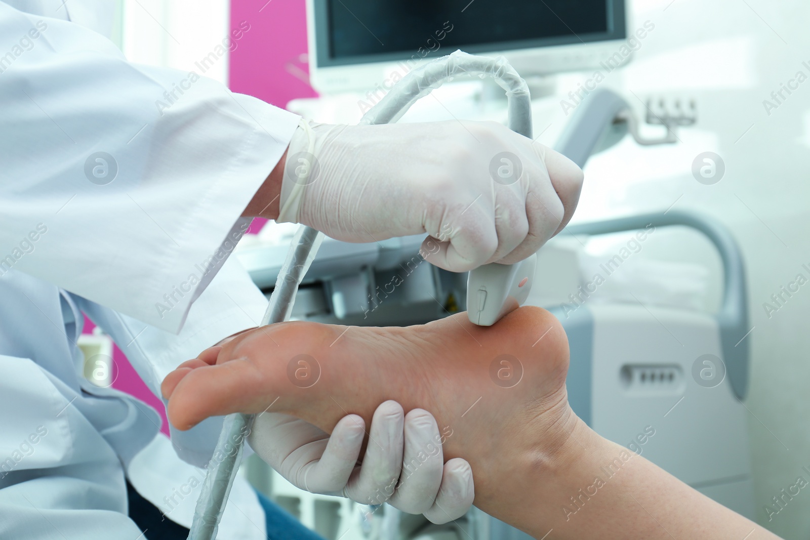 Photo of Doctor conducting ultrasound examination of patient's foot in clinic, closeup