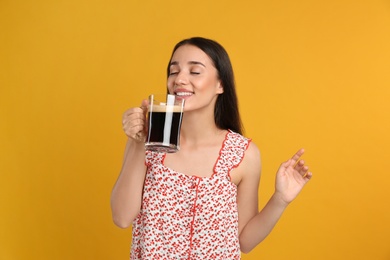 Photo of Beautiful woman with cold kvass on yellow background. Traditional Russian summer drink