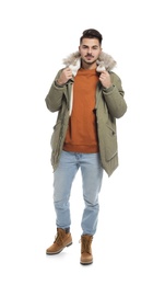 Young man wearing warm clothes on white background. Ready for winter vacation