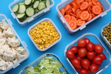 Photo of Plastic and glass containers with different fresh products on light blue background, flat lay