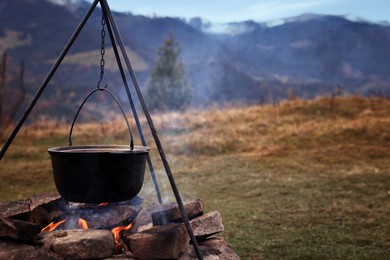 Image of Cooking food on campfire in mountains on autumn day. Camping season