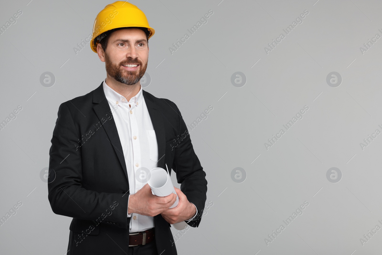 Photo of Architect in hard hat with draft on gray background, space for text