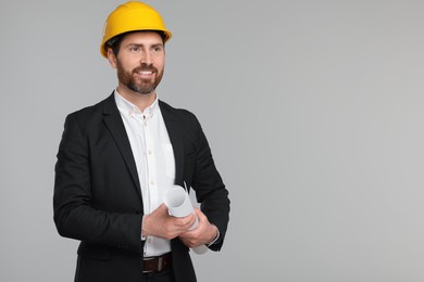 Photo of Architect in hard hat with draft on gray background, space for text