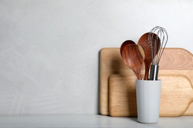 Set of kitchen utensils and boards on white wooden table. Space for text