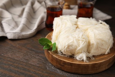 Photo of Eastern sweets. Tasty Iranian pashmak on wooden table, closeup. Space for text