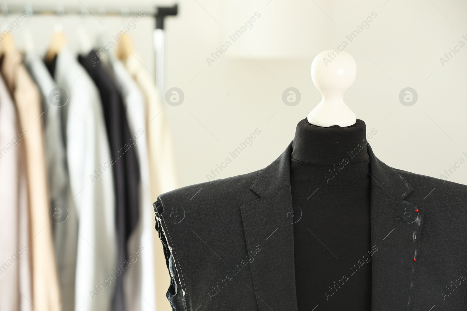 Photo of Mannequin with unfinished jacket in tailor shop, closeup. Space for text