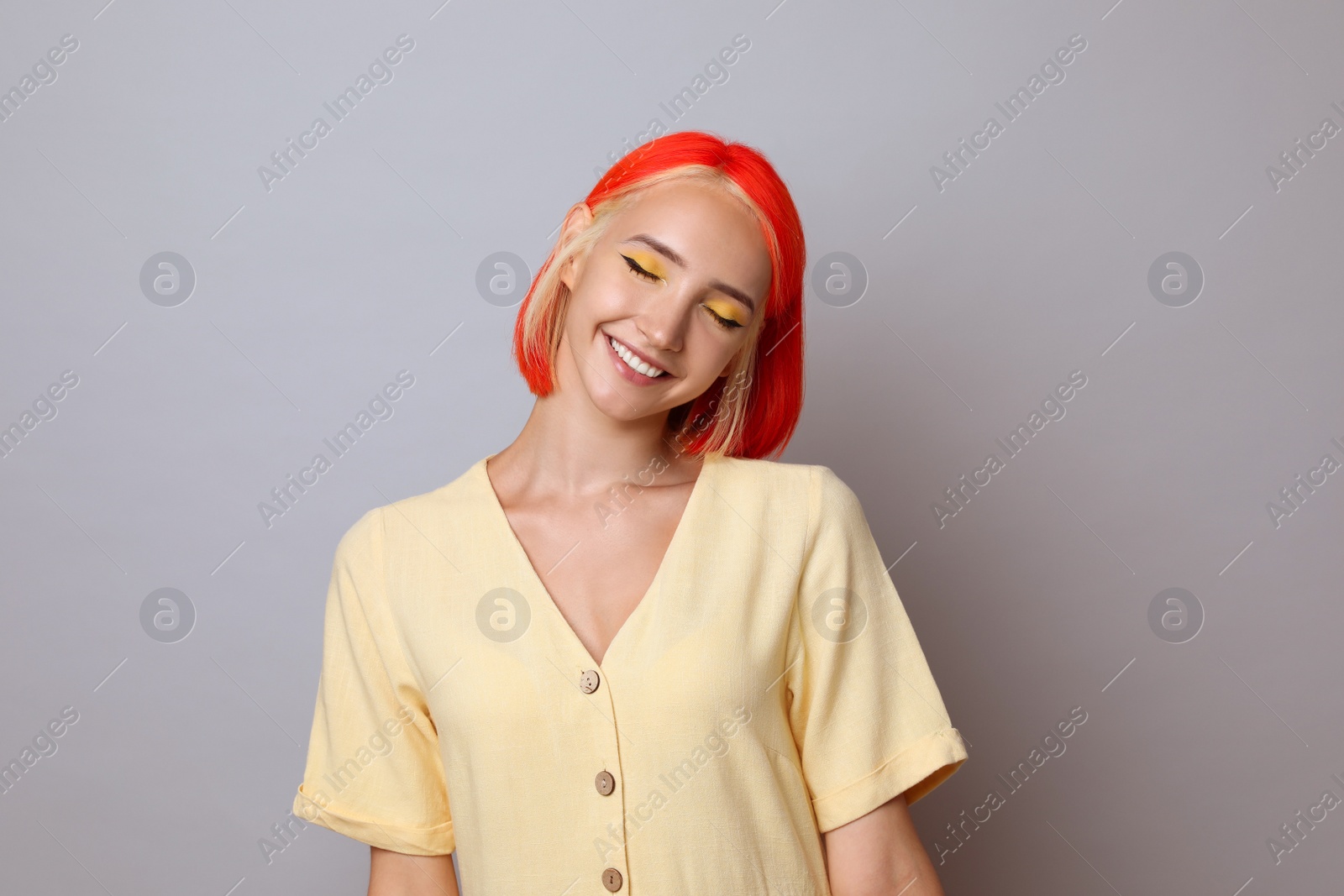 Photo of Beautiful young woman with bright dyed hair on light grey background