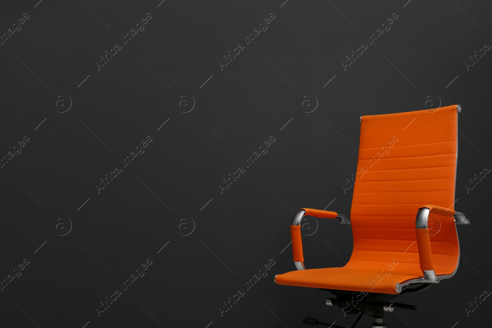 Photo of Comfortable office chair on black background. Space for text