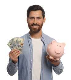 Photo of Happy man with money and piggy bank on white background