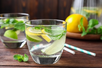 Photo of Tasty refreshing lemonade on wooden table, closeup. Summer drink