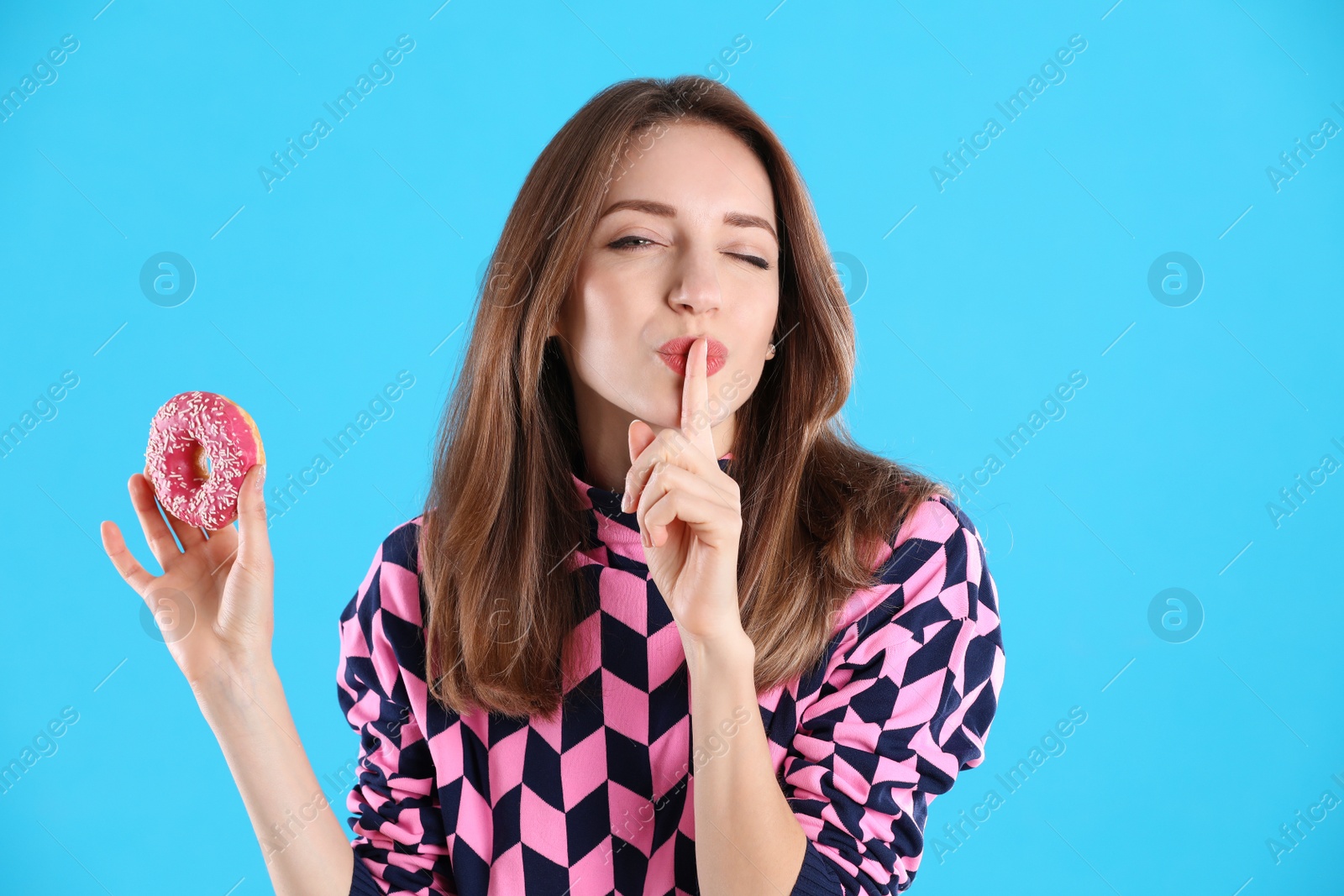 Photo of Beautiful young woman with donut on light blue background