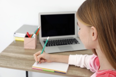 Teenager girl doing her homework at desk