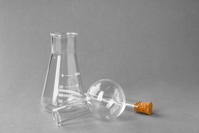 Different laboratory glassware on grey background, space for text