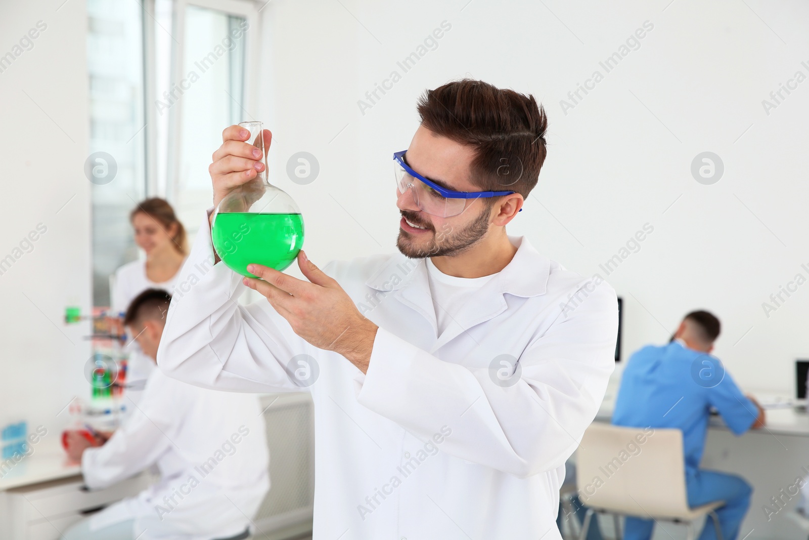 Photo of Medical student with glass flask working in modern scientific laboratory