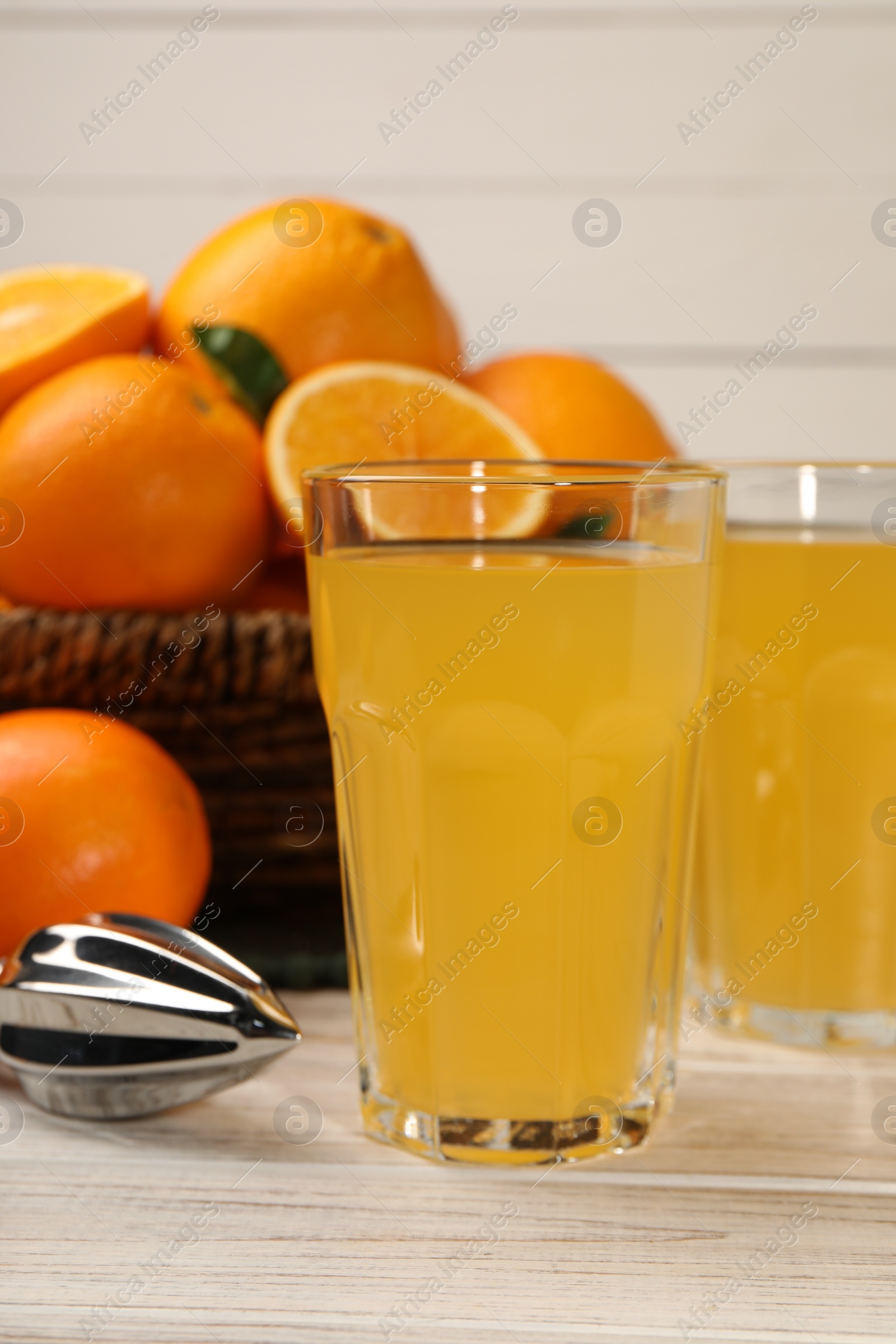 Photo of Tasty freshly made orange juice on white wooden table